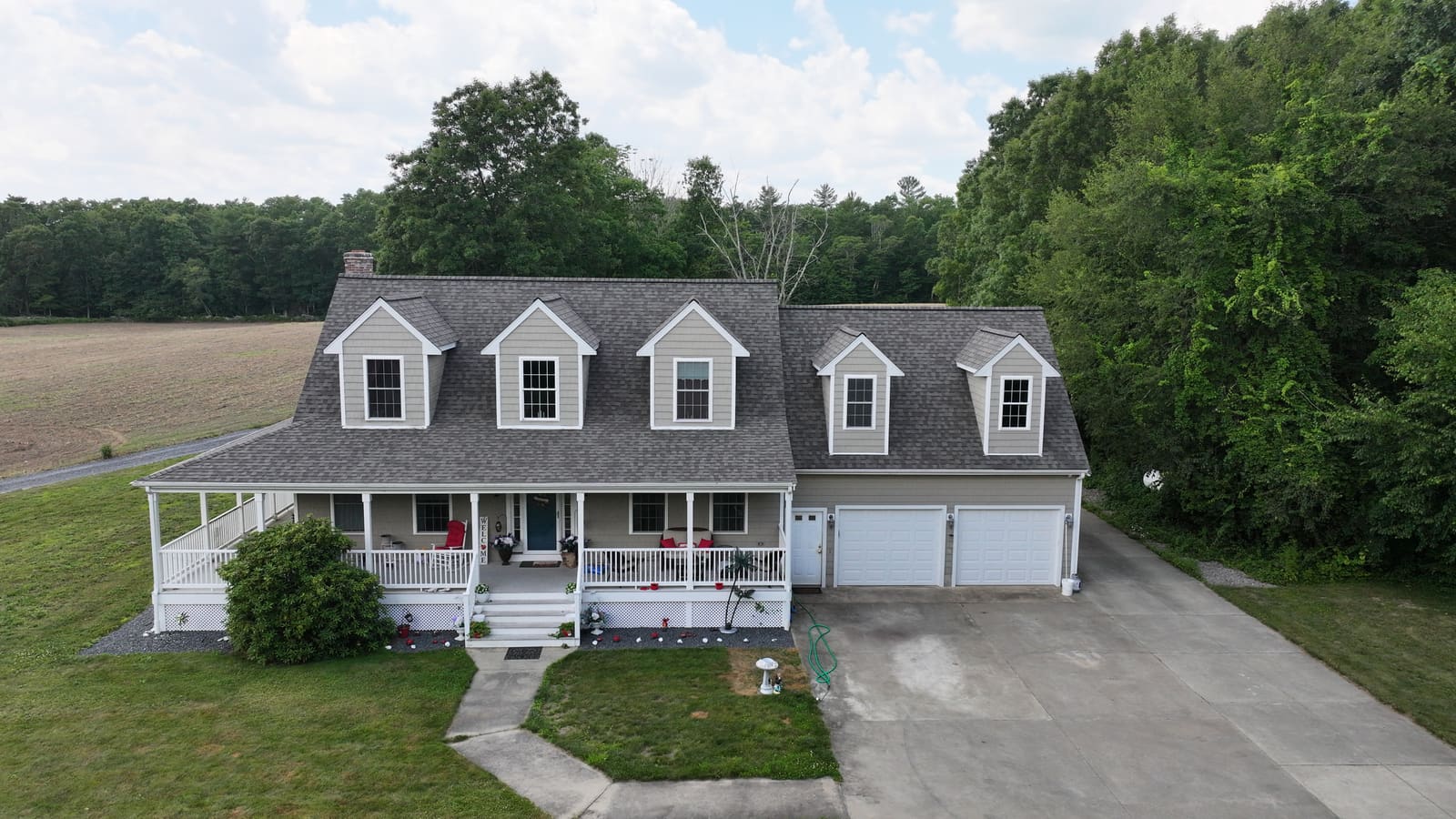 House with dormers and a gray asphalt shingle roof seen from the front