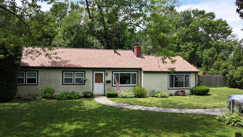 Ranch house with a tan shingle roof seen from the front