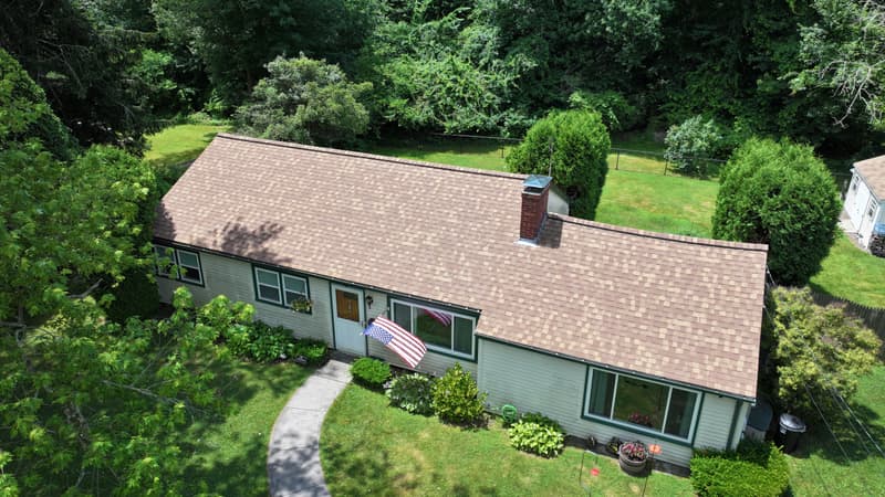Ranch house with a tan shingle roof seen from above