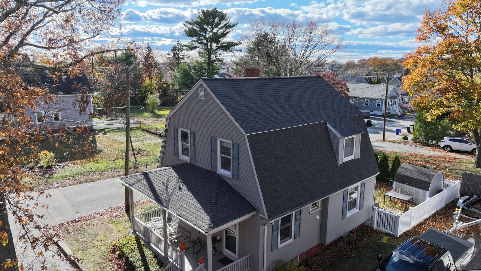 House with a gambrel roof covered in dark asphalt shingles