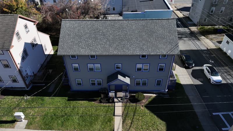 Three-story building with a gray shingle roof