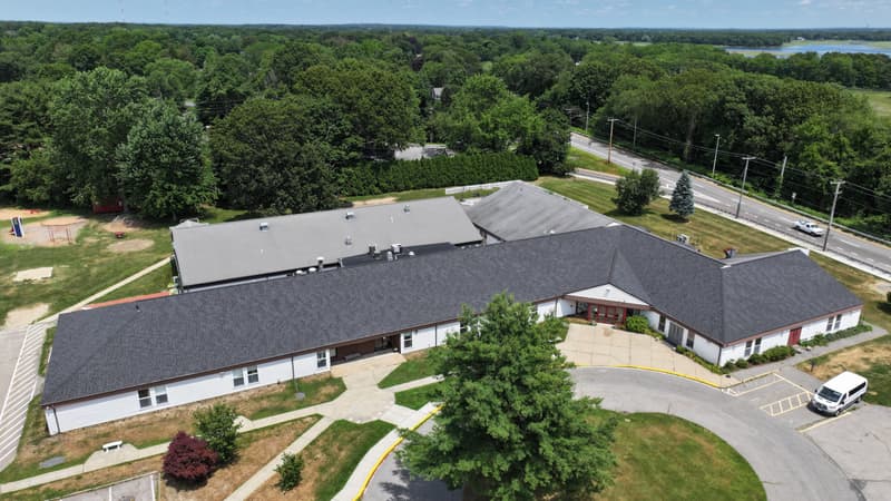 Large single-story building with a dark shingle roof seen from above
