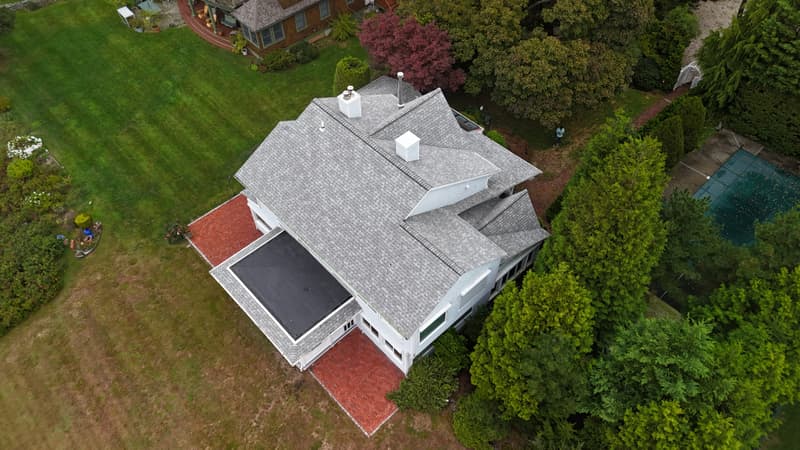 House with shingled slopes and a flat membrane section over a porch